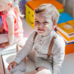Fotografía de un niño pequeño emocionado en el aula de la guardería.