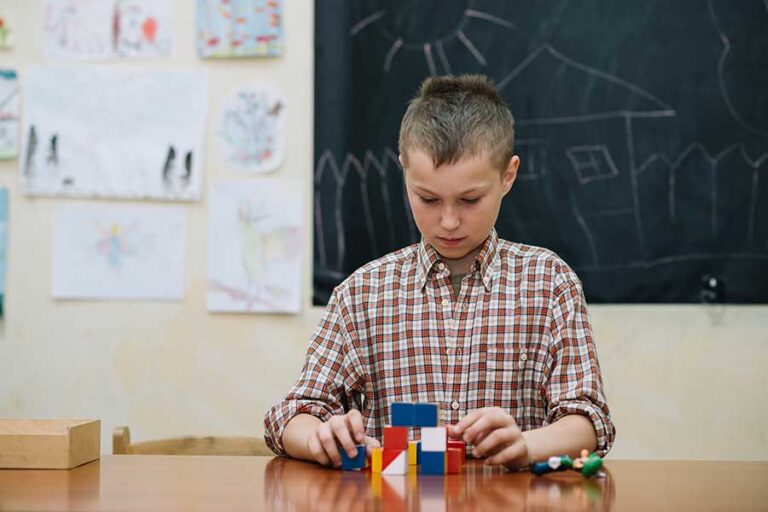 Imagen de un joven en un aula con un rompecabezas en representación del las altas capacidades o AACC.