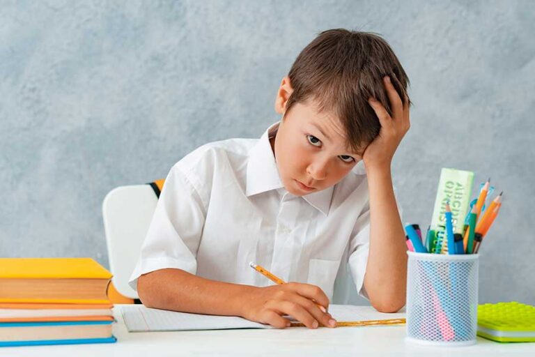 Imagen de un niño con TDAH abrumado ante los deberes de la escuela.